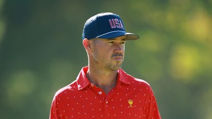 Man wearing red polo and cap