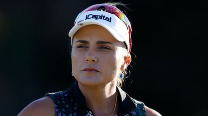 Female golfer wearing white visor