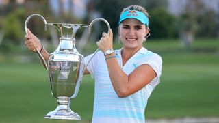 Woman proudly holds golden trophy