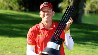 Man holding trophy wearing red cap