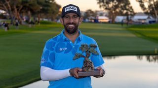 Golfer celebrates with championship trophy