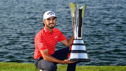 Man kneels with gaming trophy