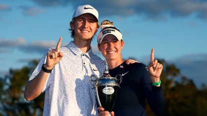 Two golfers celebrate with trophy