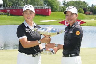 Women holding tennis doubles trophy