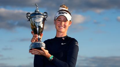 Woman holds silver victory trophy