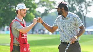 Golfer and caddy fist bump