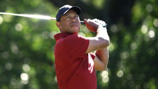 Golfer mid-swing on golf course