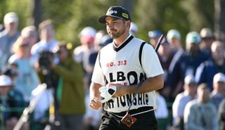 Golfer in vest swings club